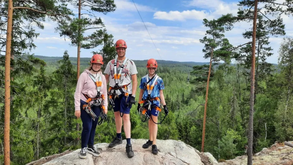 Zwei mit Kindern mit deren Vater, sind bereit fürs Ziplining.
