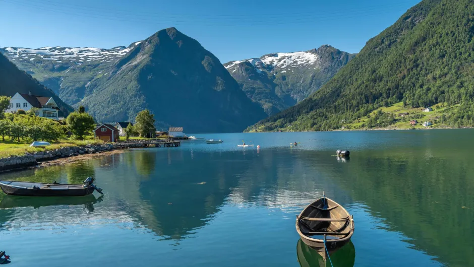 Blick auf Berge im Hintergrund und einen See im Vordergrund.