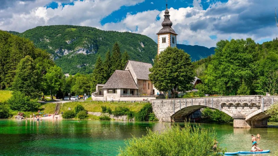 Dorfszene mit einer Kirche, deren hoher Kirchturm herausragt.