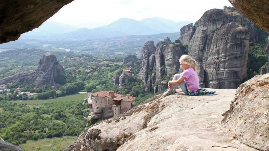 Fünf Gründe für eine Familienreise nach Griechenland, Kind sitzt auf den Felsen in Meteora, Griechenland.
