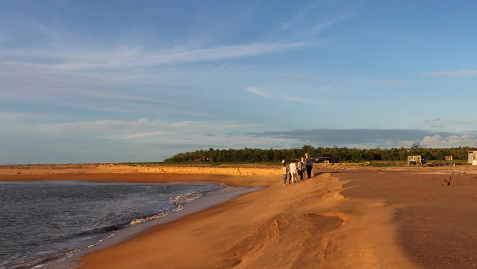 Eine Familie läuft am Strand von Suriname