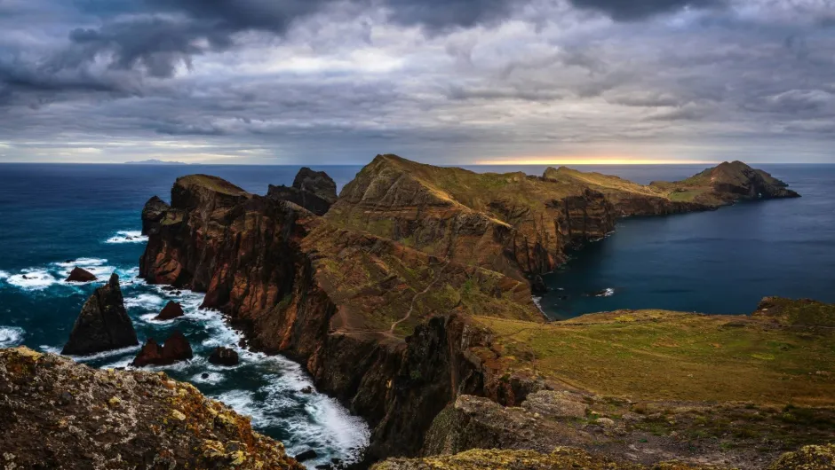 Felsformationen an einem dunkelblauen Meer.