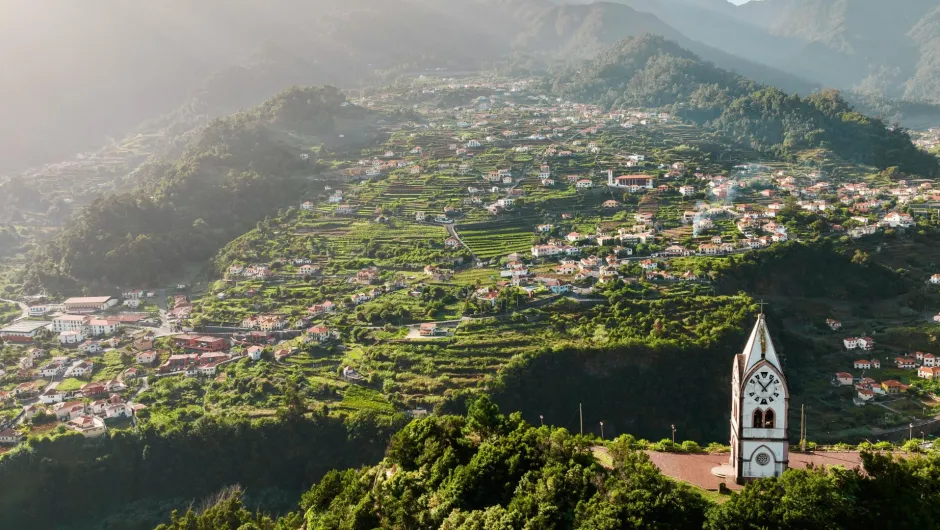Beste Reisezeit Madeira: Aussichtspunkt auf Madeira mit Blick über grüne Hügel und Wolkenmeer.