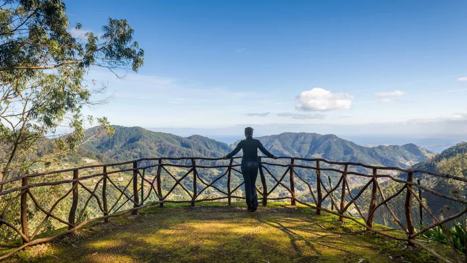 Madeira Reisen: Frau blickt vom Aussichtspunkt im Park von Santo da Serra auf die Berglandschaft.