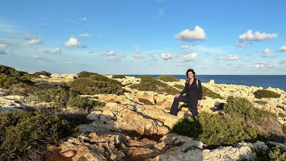 Niki stehend auf Steinklippen an der Küste.