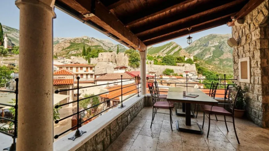 Traditionelles Hüttendorf mit Steinhäusern und blühendem Garten.