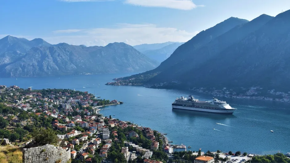 Panoramablick auf die Bucht von Kotor mit Kreuzfahrtschiff und umliegenden Bergen.
