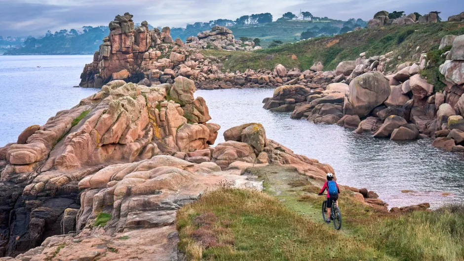 Radfahrerin an der Granitküste der Bretagne.