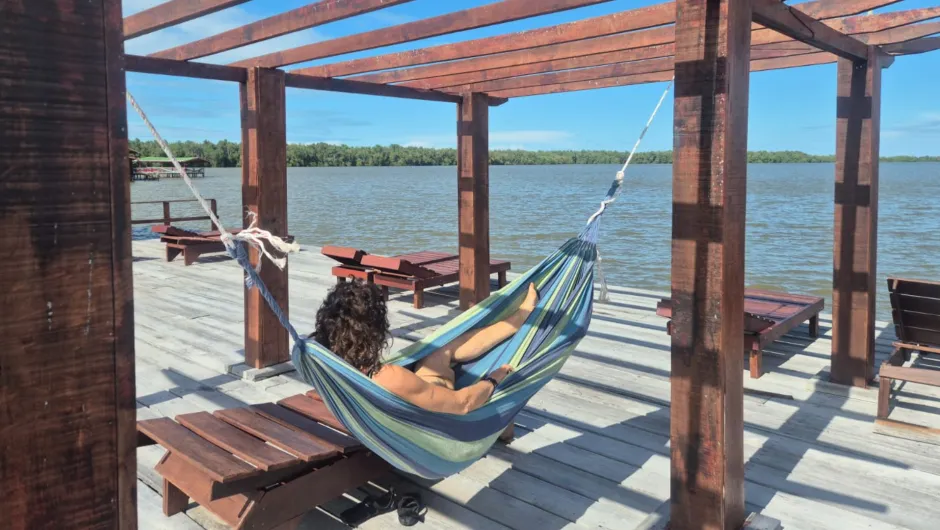 Eine Frau genießt die aussicht von der Bigi Pan Mantjes Lodge in Suriname.