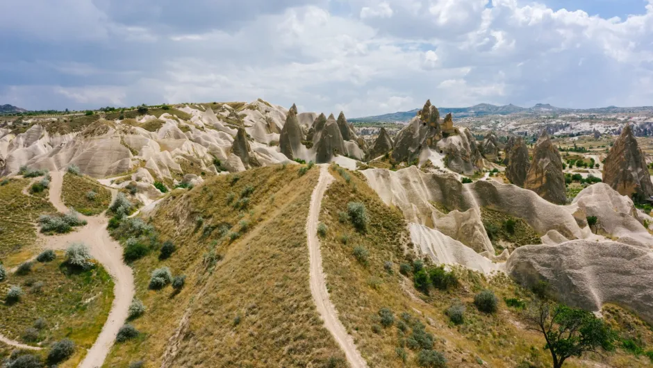 Felslandschaft in Kappadokien in der Türkei mit markanten Tuffsteinformationen und sogenannten Feenkaminen unter einem bewölkten Himmel.