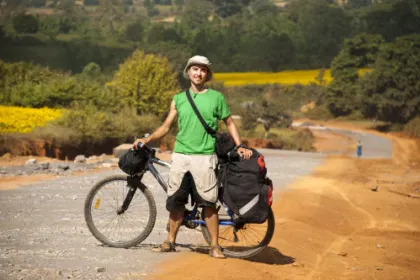 Ein Mann steht in Myanmar mit deinem Fahrrad auf einem Weg