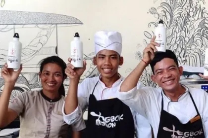Drei Personen aus Kambodscha halten wiederbefüllbare Flaschen hoch