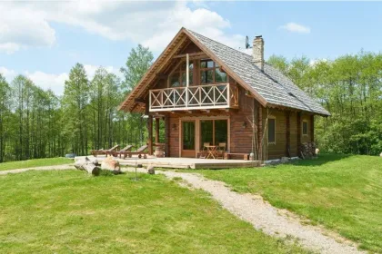 Aufnahme von draußen des Holzhomestays Dabintos Slenis in einem Wald, Litauen.