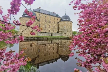 historische Burg mit mehreren runden Türmen und einem steilen Dach.
