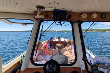 Gruppe von Menschen, die auf dem Deck eines Bootes sitzen.
