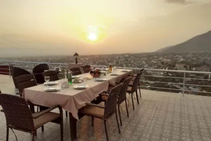 Hotel balkon mit ein lanfger Tisch beim Sonnenuntergang.