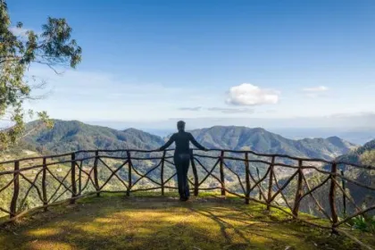 Frau blickt vom Aussichtspunkt im Park von Santo da Serra auf die Berglandschaft.