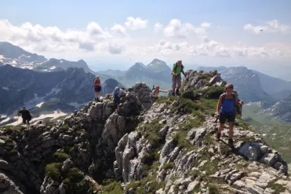 Menschen, die auf dem Gipfel eines felsigen Berges eine Trekkingtour unternehmen.