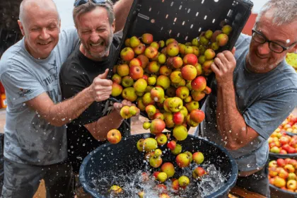 3 Männer lachend bei der Cidre Herstellung in der Normandie.