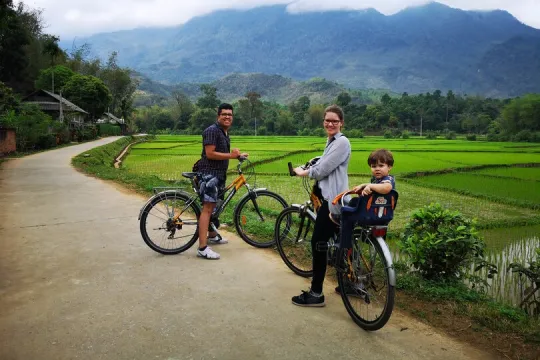 eine Familie auf ihrer Radtour durch das Reisfeld, Vietnam.