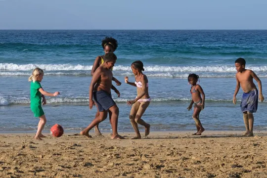 Kinder spielen am Strand.