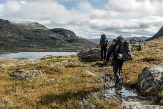 Zwei Menschen auf Trekkingtour durch ein Tal zwischen den Bergen Montenegros.