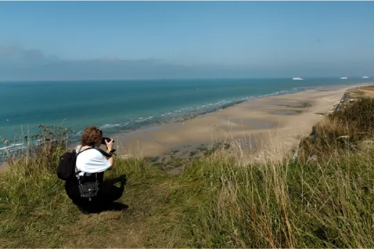 grasbewachsenen Klippe und das blaue Meer mit Schiffen am Horizont.